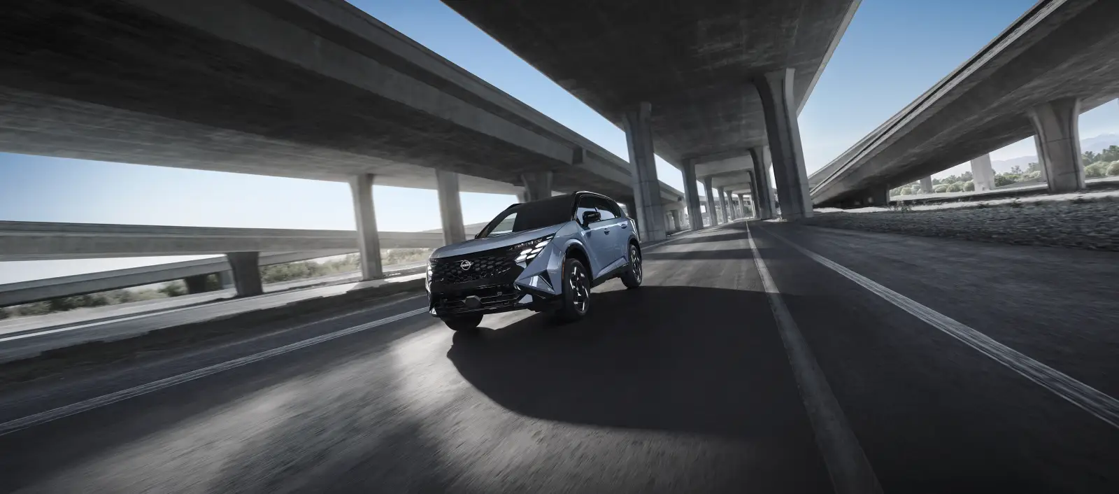 2027 Rogue Hybrid driving under a highway overpass
